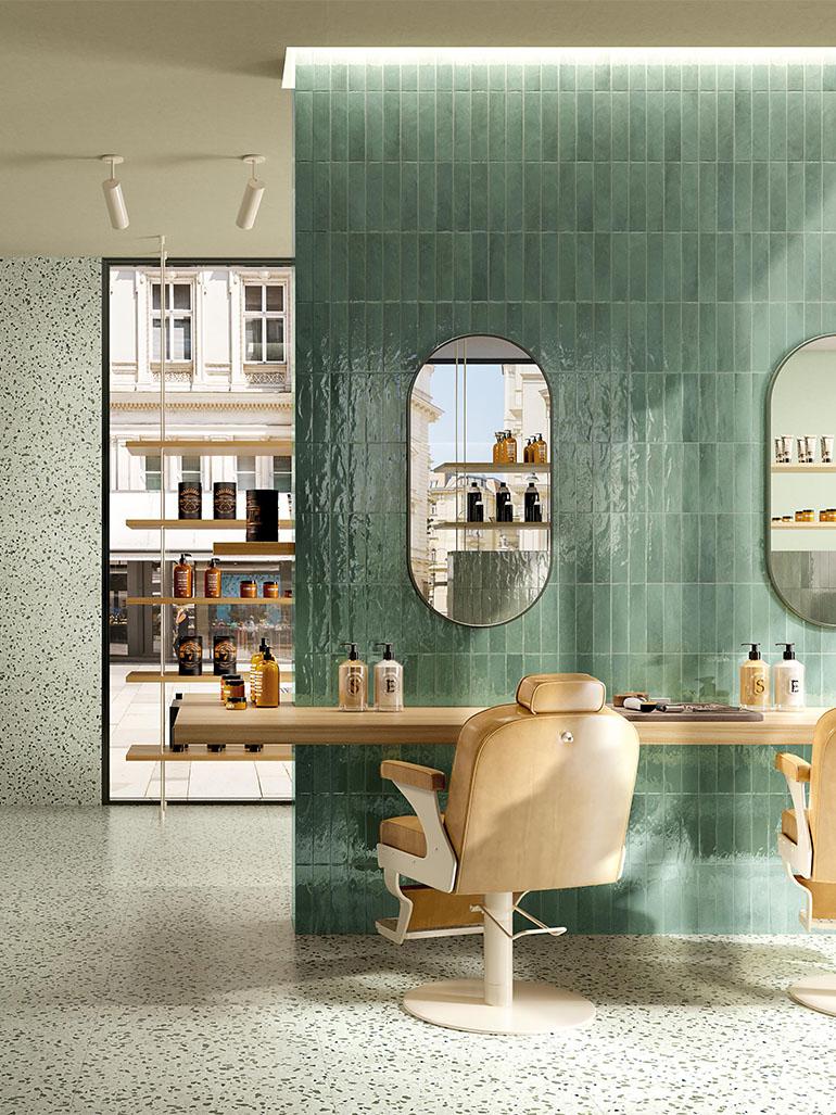 Nell’immagine, originale barber shop realizzato con GLIM, una collezione vitaminica capace di decorare gli ambienti con il colore, grazie a brick smaltati dal finish brillante. A parete, nel formato 6x24cm, Salvia - colore fresco, quasi terroso e ricco di venature – e Gemme Salvia, effetto terrazzo coordinato con finitura opaca. A pavimento sempre Gemme Salvia, nel formato 60X60.